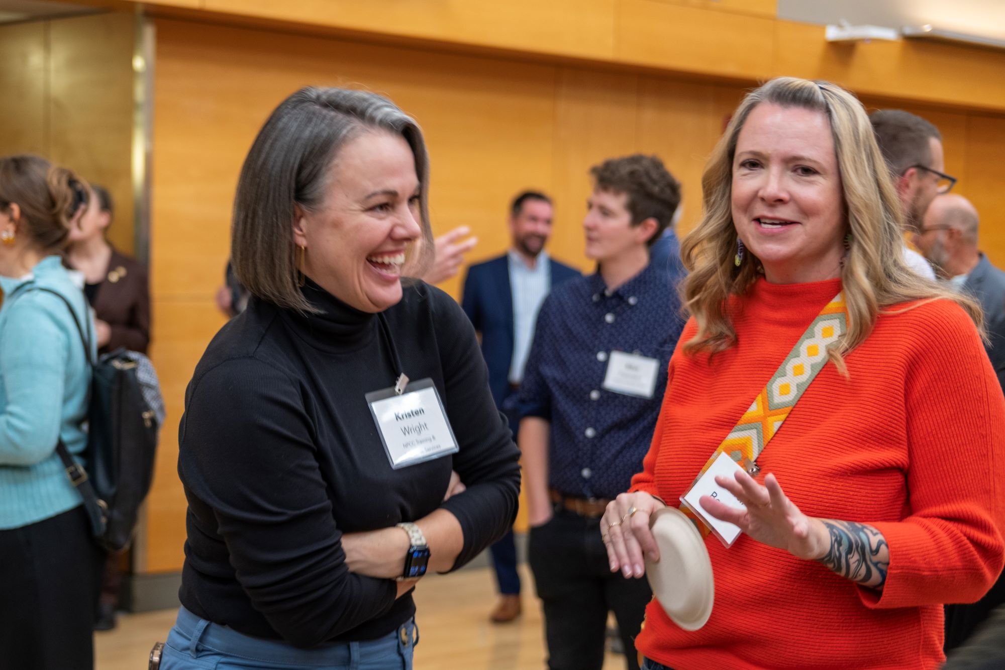 Two women smiling and laughing during the Oregon Consensus celebration party.